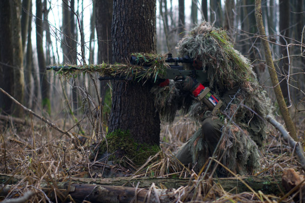 Airsoft sniper camuflado em um campo aberto